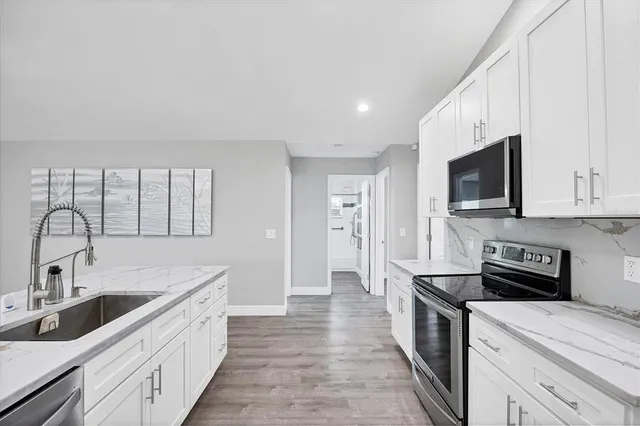 a kitchen with stainless steel appliances a white stove top oven and sink