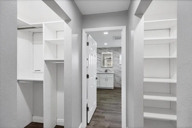 a bathroom with a walk in closet and a glass door