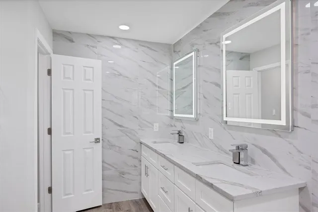 a bathroom with double vanity sink and a mirror
