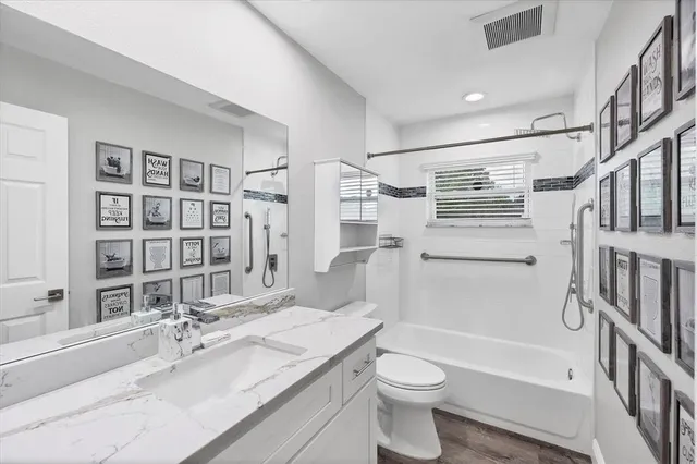 a bathroom with a granite countertop sink toilet and shower