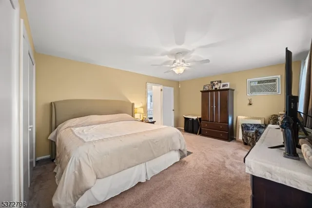 a spacious bedroom with a bed and a flat screen tv