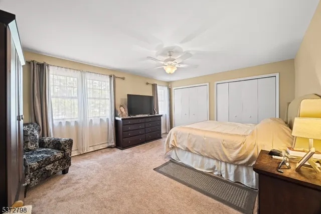 a bedroom with a bed potted plant on dresser and a window