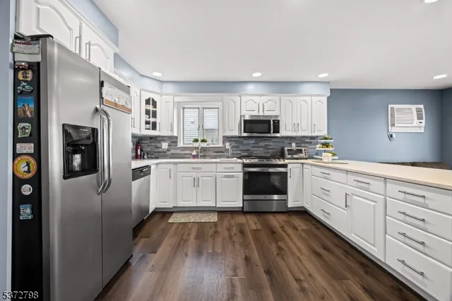 a kitchen with white cabinets stainless steel appliances and sink