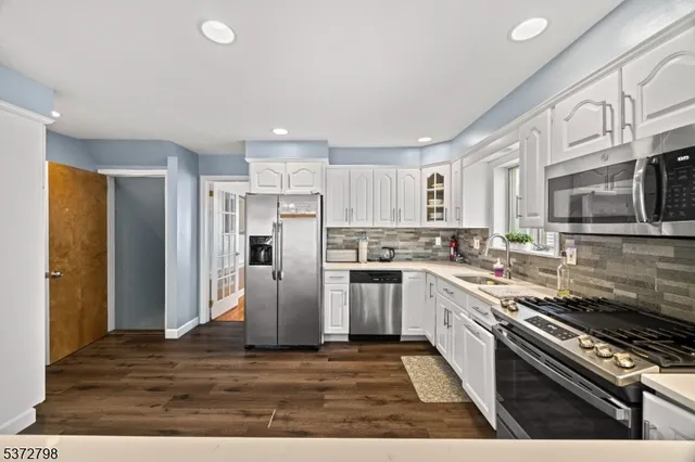 a kitchen with stainless steel appliances kitchen island granite countertop a refrigerator and a stove top oven