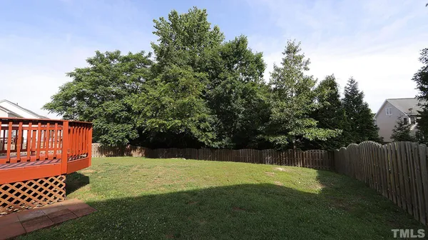 a view of backyard with wooden fence