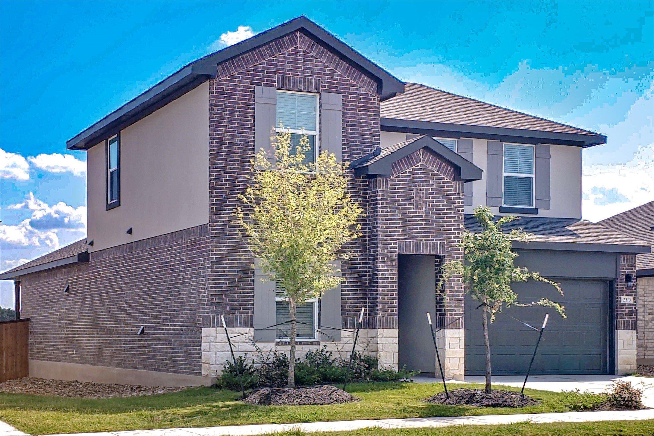 2313 March Hare Trace Leander, TX 78641 - Photo 2 of 30 View of front of house with brick siding, an attached garage, and stucco siding