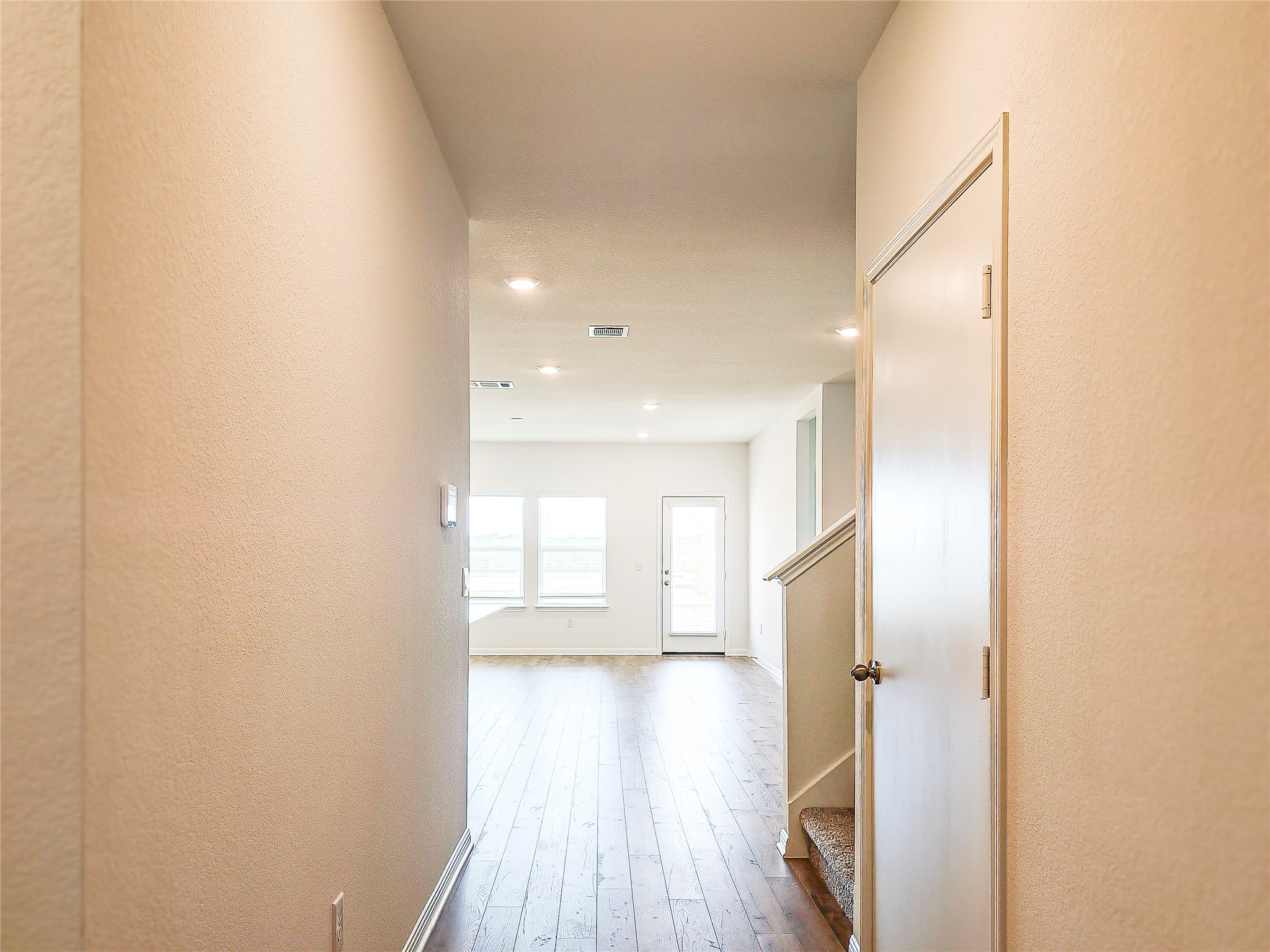 2313 March Hare Trace Leander, TX 78641 - Photo 4 of 30 Hallway with light wood finished floors, a textured wall, and recessed lighting