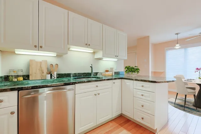 a kitchen with granite countertop white cabinets and white appliances