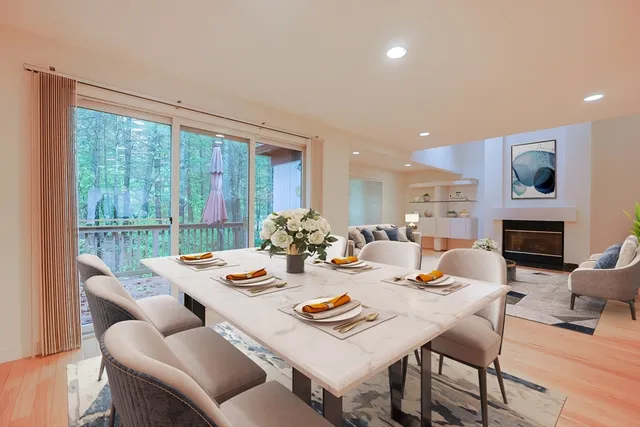 a dining room with furniture a large window and a fireplace