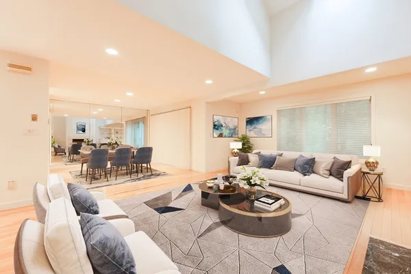 a living room with furniture and a view of kitchen