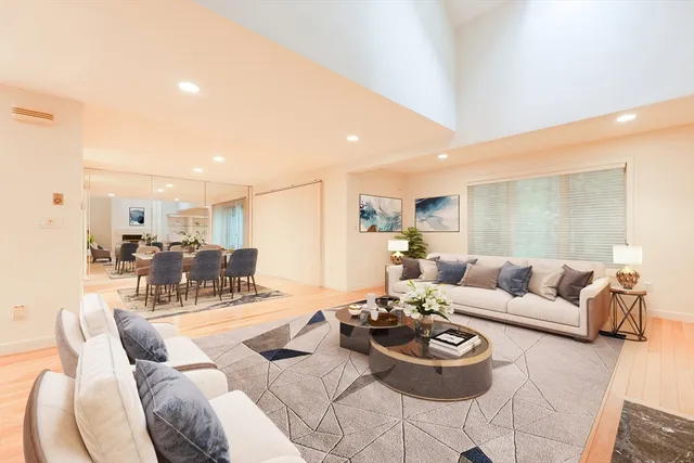 a living room with furniture and a view of kitchen