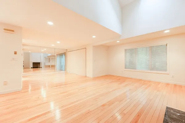 a view of empty room with wooden floor