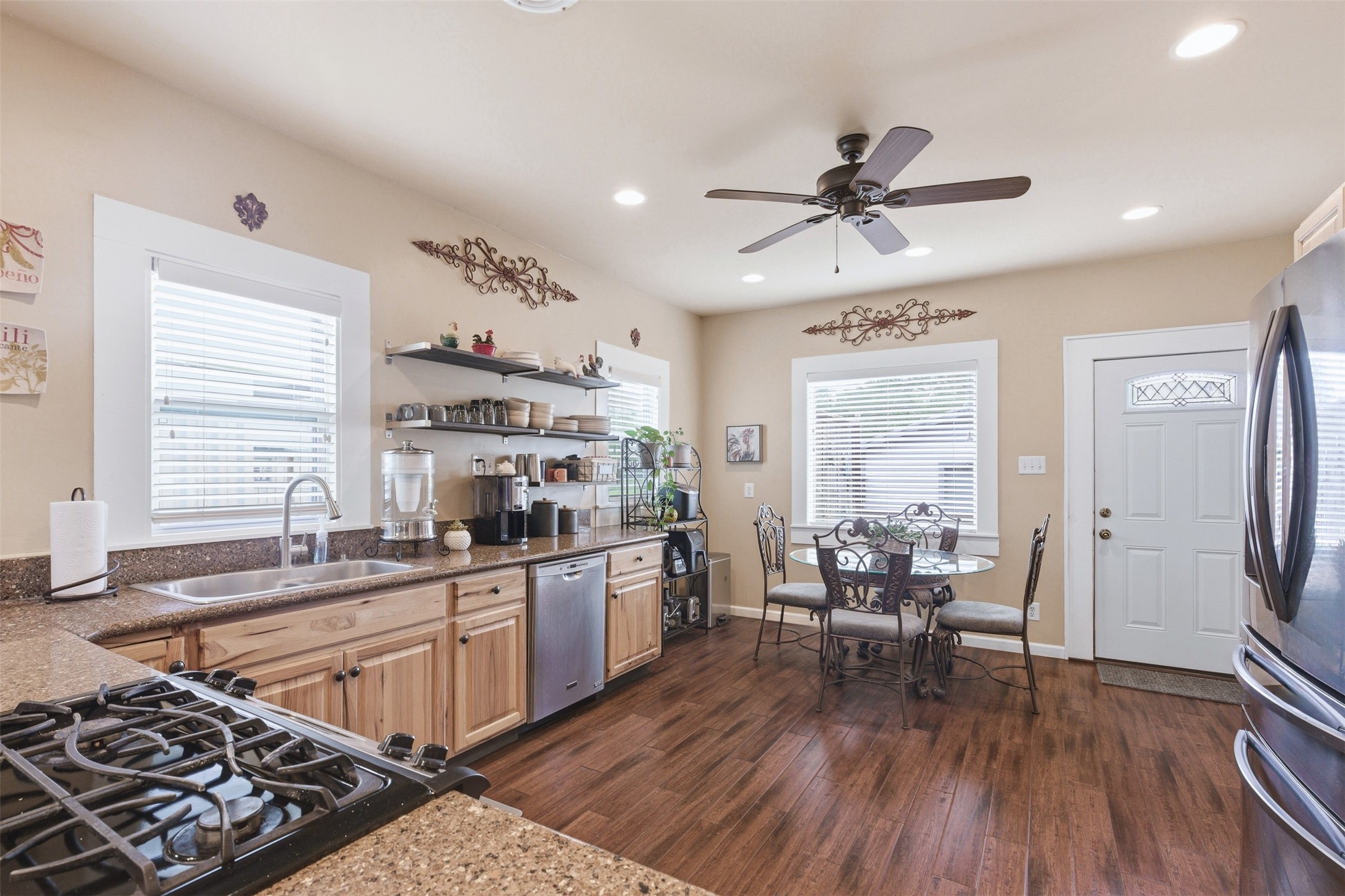 1726 13th Street Hempstead, TX 77445 - Photo 9 of 40 a kitchen with stainless steel appliances a stove a sink dishwasher and a dining table with wooden floor