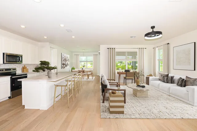 a living room with furniture wooden floor and a large window