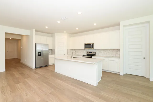 a kitchen with a sink a stove top oven and white kitchen