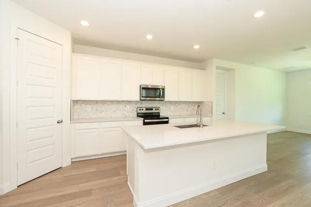 a open kitchen with kitchen island a sink a stove and a refrigerator