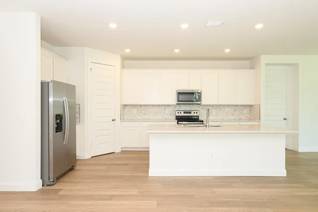 a large kitchen with stainless steel appliances lots of counter top space and cabinets
