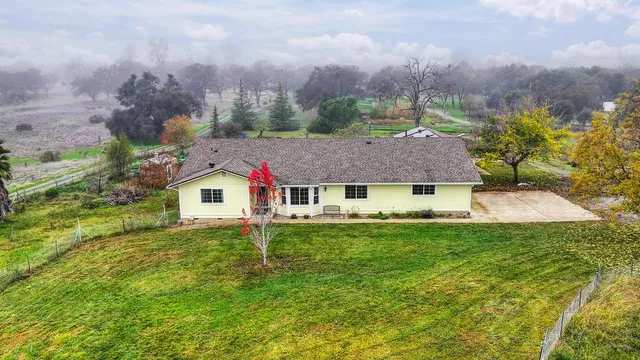 an aerial view of residential houses with yard and mountain view in back