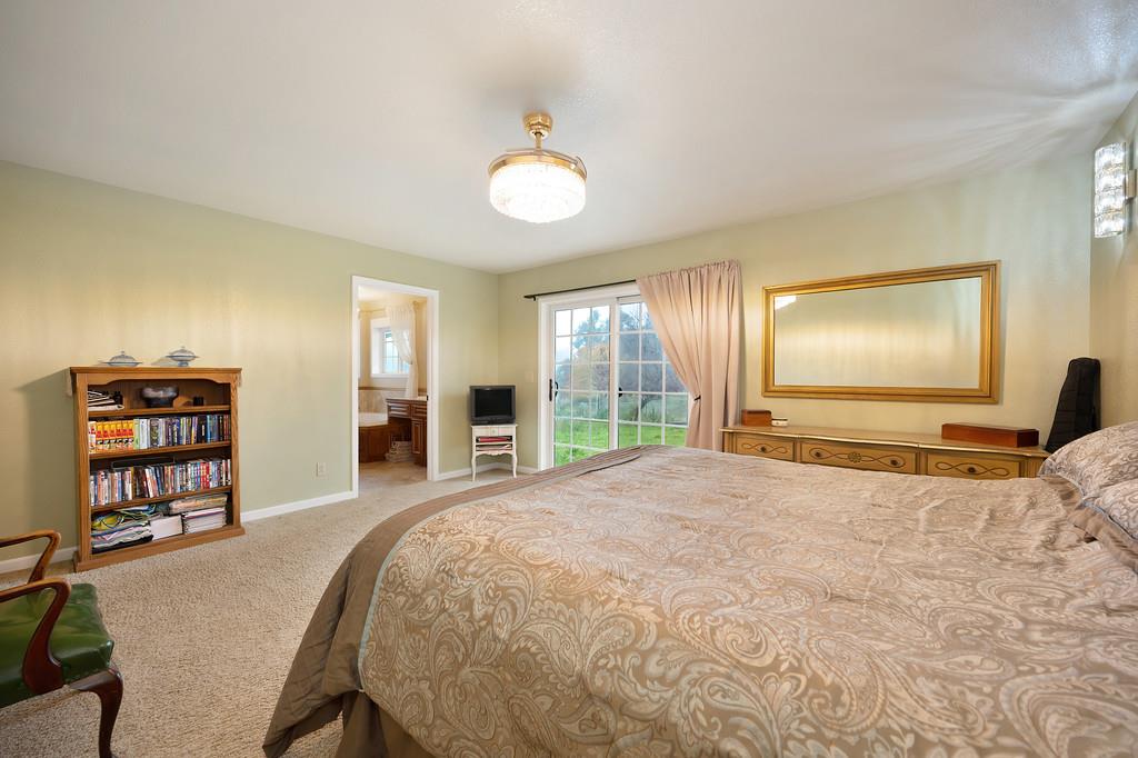 12156 Scott Grant Road Marysville, CA 95901 - Photo 40 of 77 a spacious bedroom with a large bed and a flat screen tv