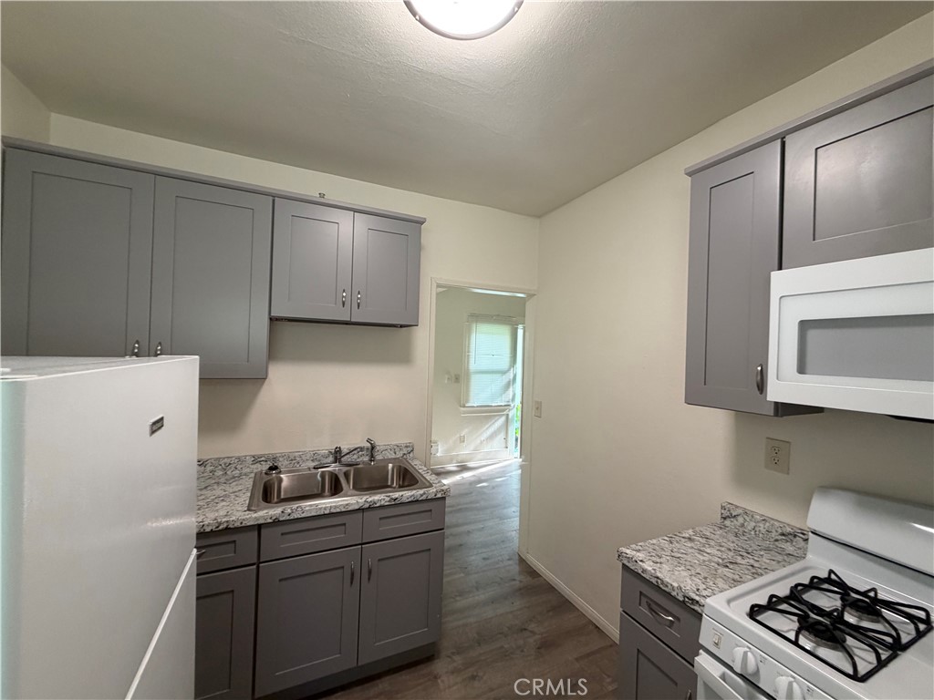 1917 East 4th Street, Unit 9 Long Beach, CA 90802 - Photo 3 of 14 a kitchen with stainless steel appliances a stove a microwave and a refrigerator