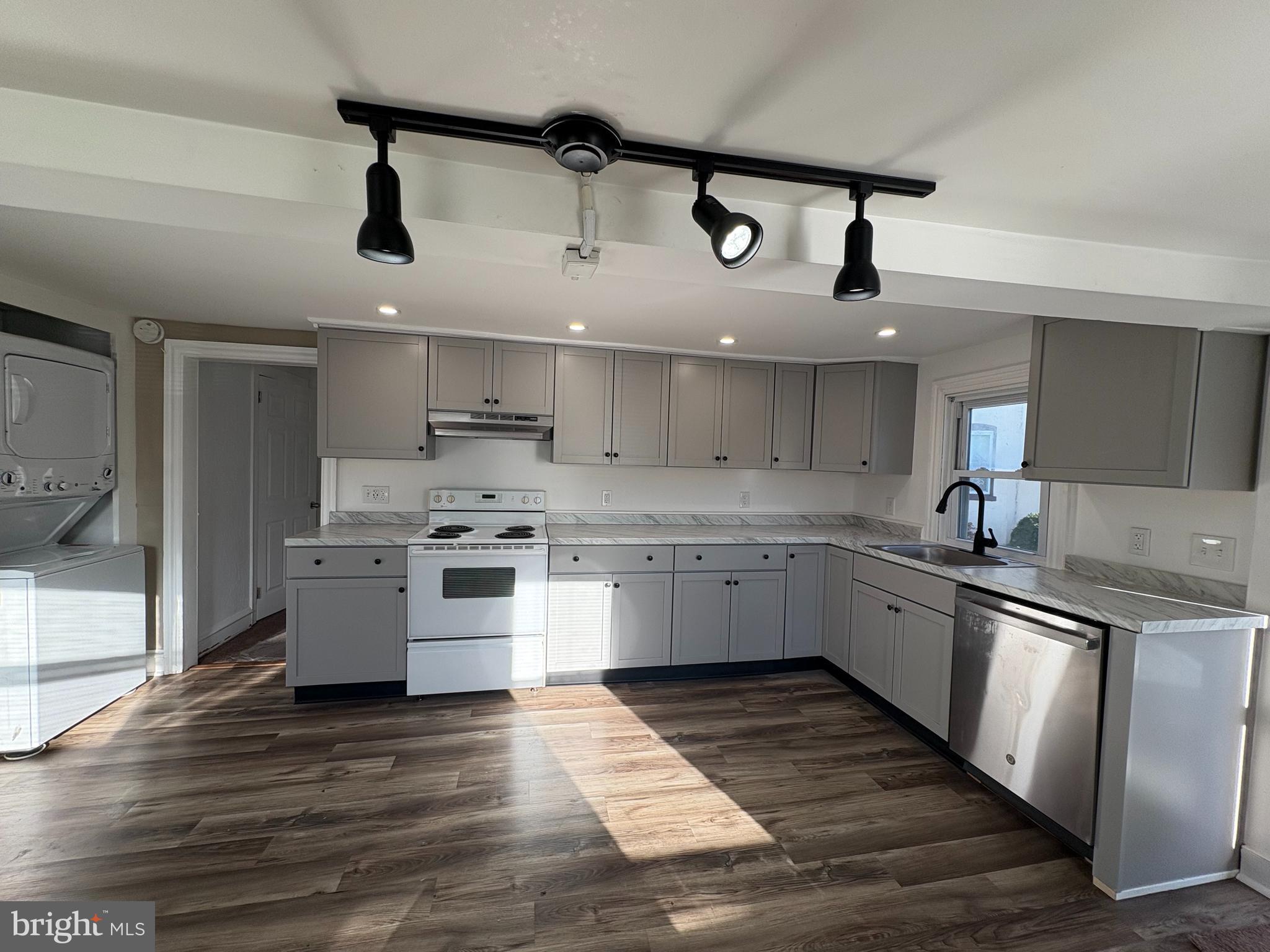 a kitchen with stainless steel appliances a stove a sink and white cabinets