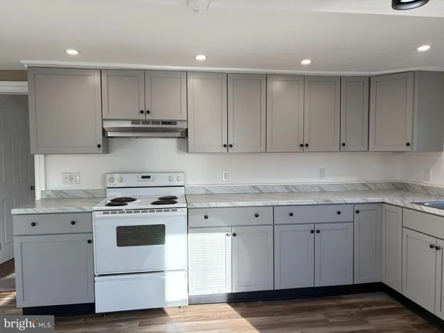 a kitchen with granite countertop white cabinets and white appliances