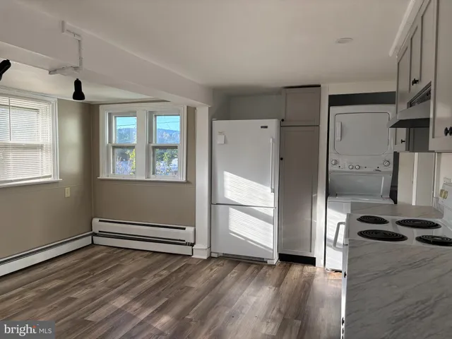 a view of empty room with wooden floor and window