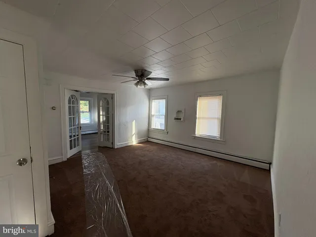 an empty room with windows and cabinet