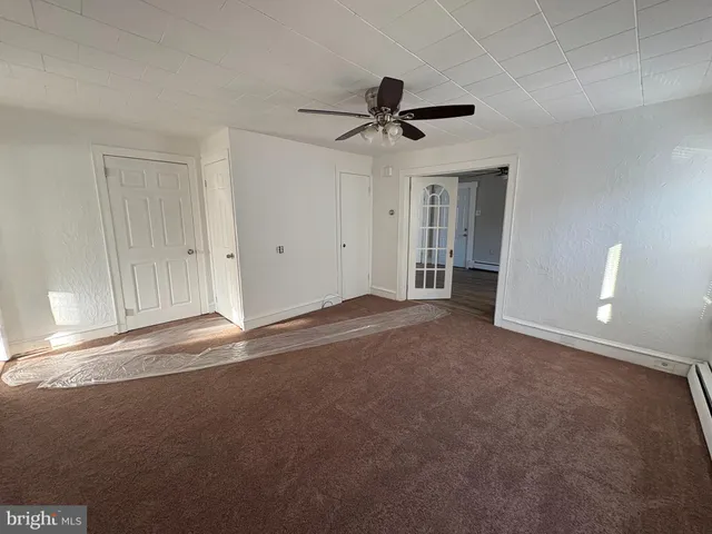 a view of a livingroom with a ceiling fan and window