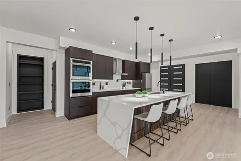 a kitchen with stainless steel appliances kitchen island granite countertop a table chairs stove and refrigerator