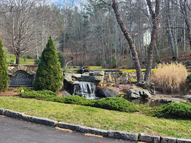 a view of a house with a garden and trees