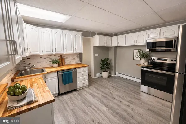 a kitchen with stainless steel appliances kitchen island granite countertop a stove a sink and a microwave