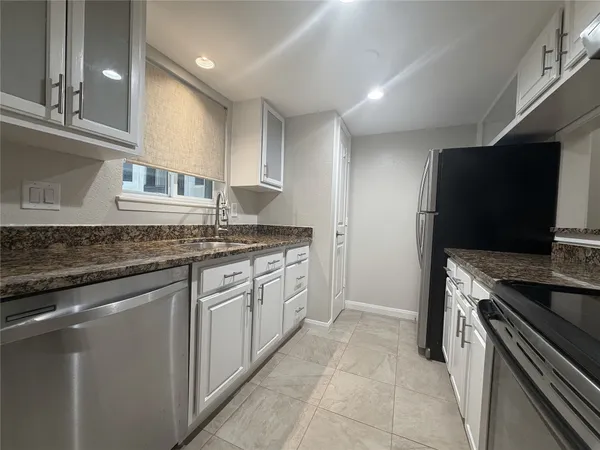 a kitchen with stainless steel appliances granite countertop a sink and a stove