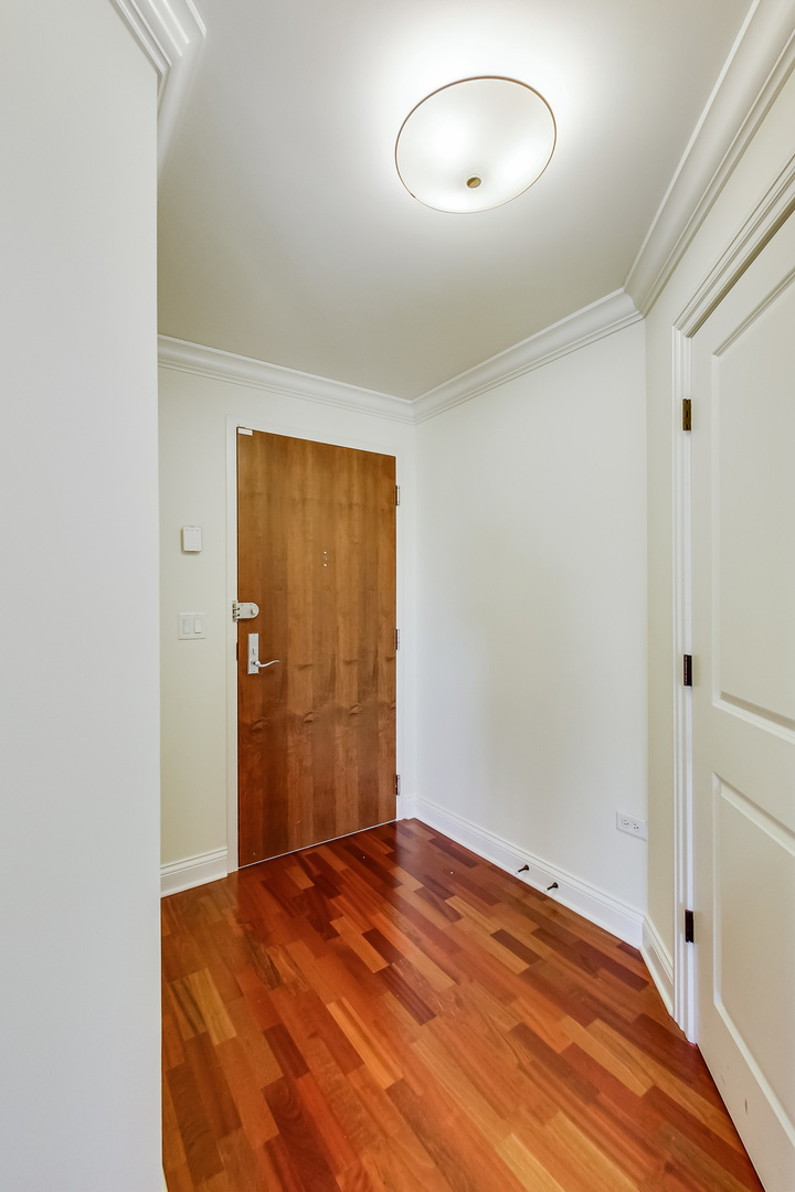 600 West Touhy Avenue, Unit 303 Park Ridge, IL 60068 - Photo 6 of 32 an empty room with wooden floor and closet