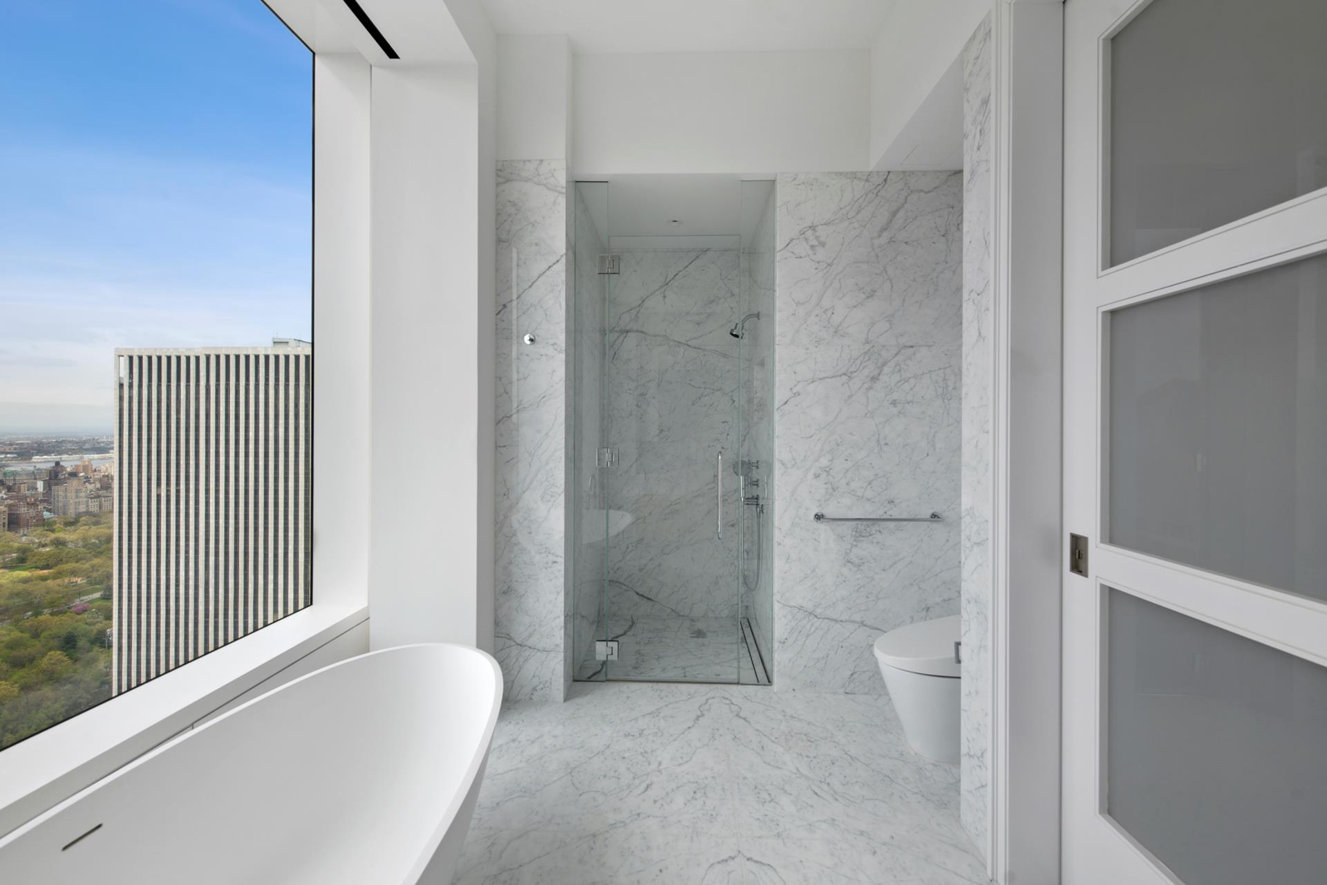 a bathroom with a granite countertop bathtub shower and toilet