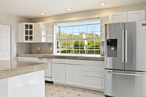 a kitchen with white cabinets and white appliances