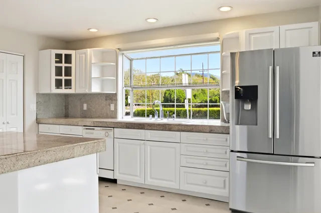 a kitchen with white cabinets and white appliances