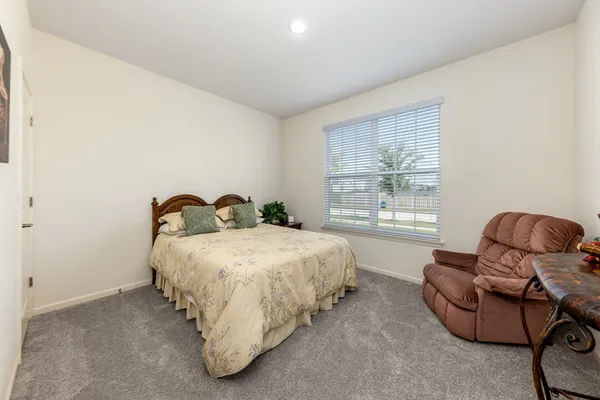 a spacious bedroom with a bed and glass window