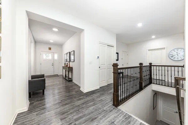 a view of a hallway with wooden floor and stairs
