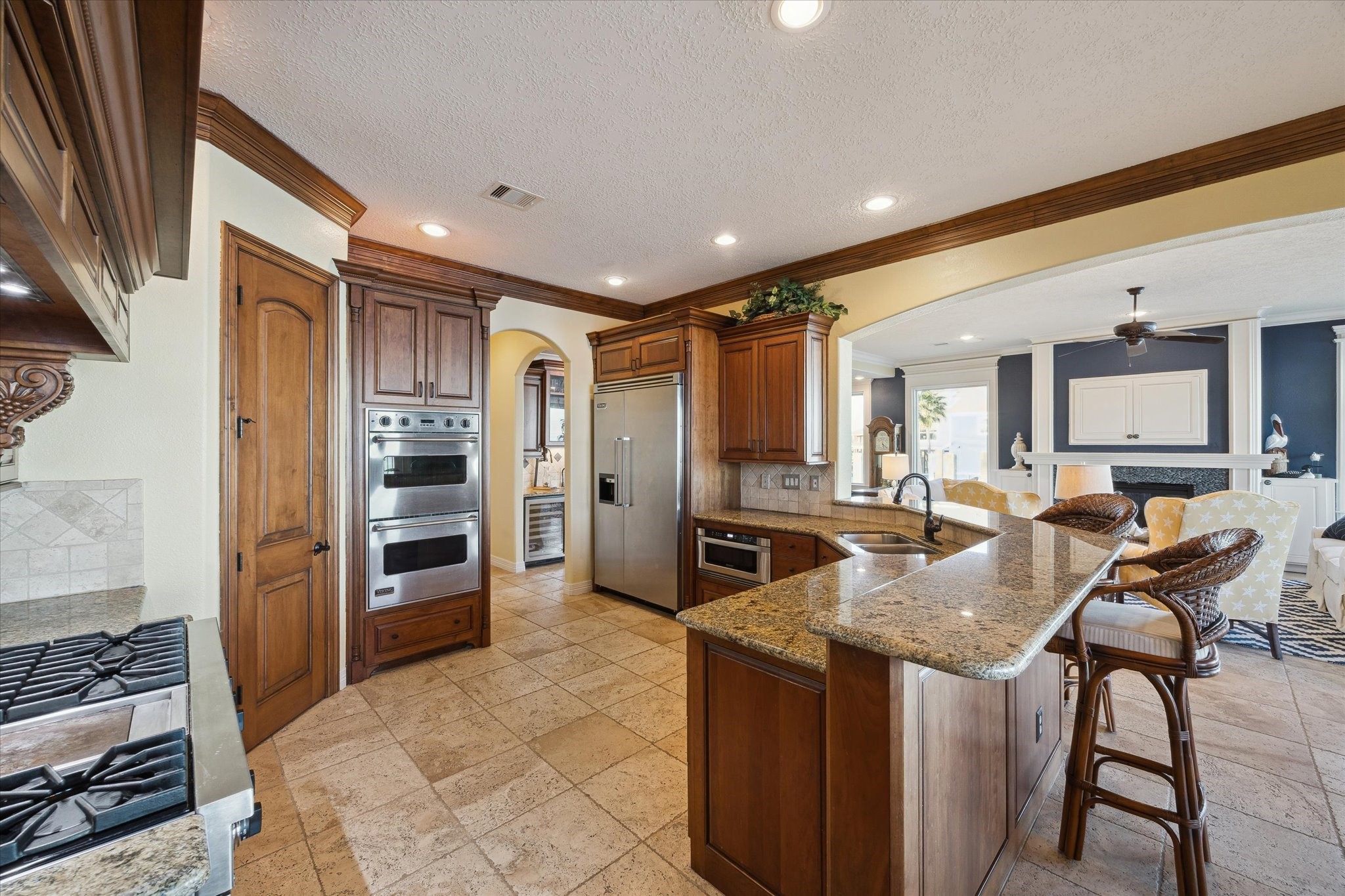 1406 Todville Road Seabrook, TX 77586 - Photo 23 of 50 NICELY FINISHED KITCHEN WITH GRANITE COUNTERS, TRAVERTINE BACKSPLASH, BREAKFAST BAR AND BUILT-IN REFRIGERATOR.