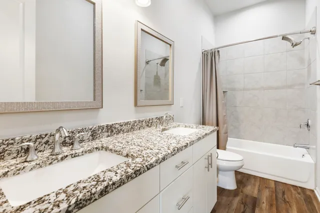 a bathroom with a granite countertop tub sink and mirror