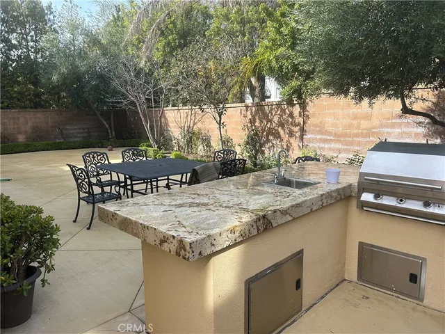 a patio with table and chairs and potted plants