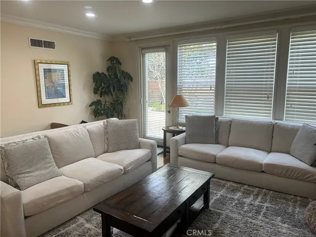 a living room with furniture a large window and a wooden floor