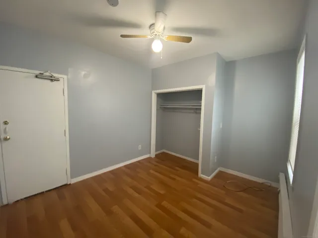a view of a room with a ceiling fan and a hardwood