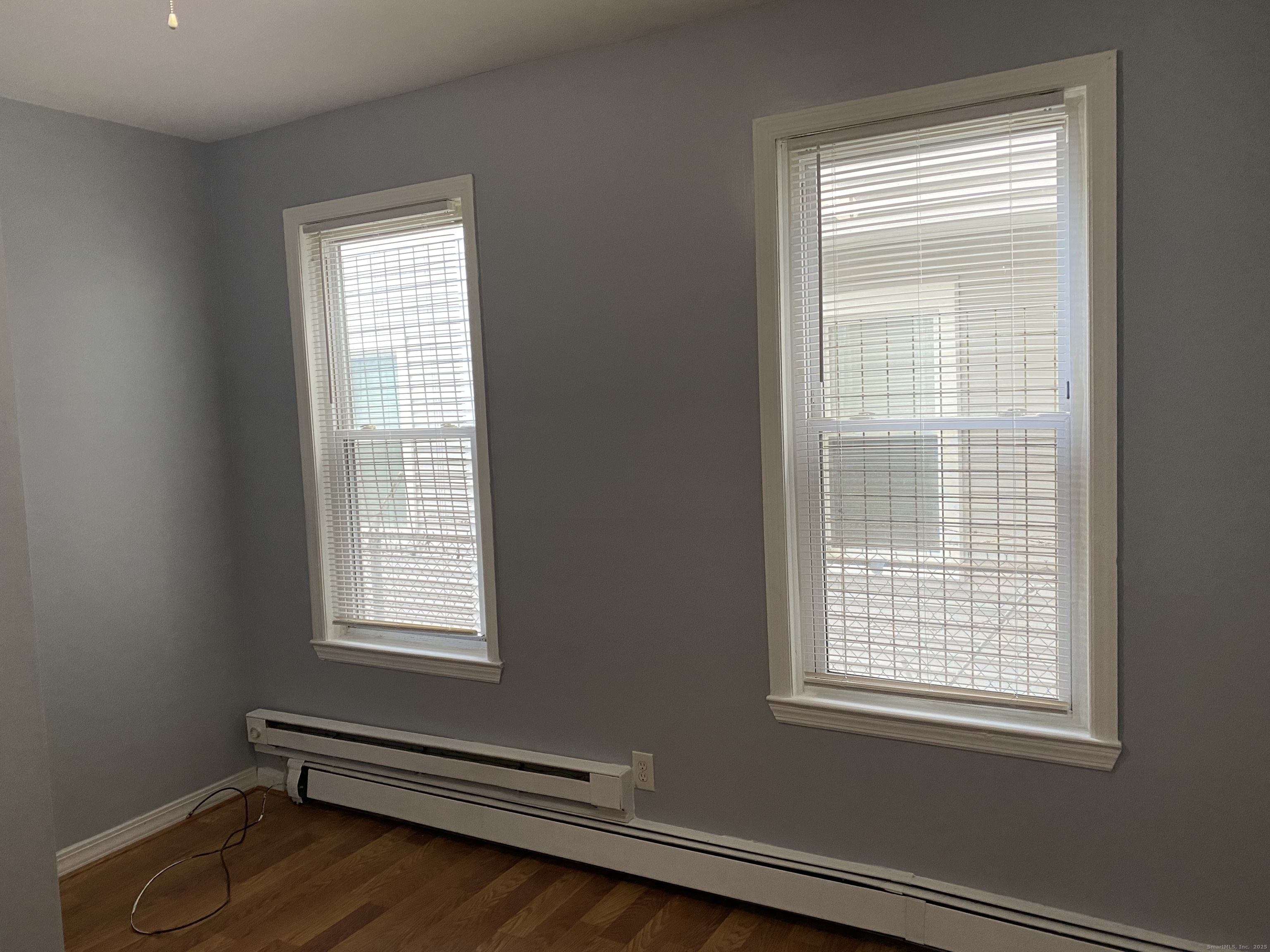 1458 East Main Street, Unit 2 Bridgeport, CT 06608 - Photo 4 of 6 an empty room with wooden floor and windows