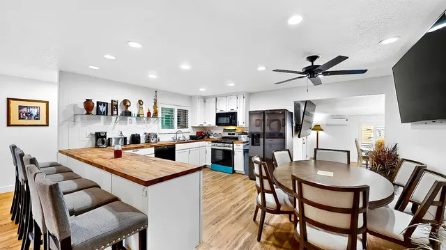 a kitchen with a dining table chairs and refrigerator