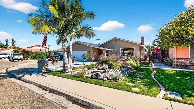 a front view of a house with a garden and a yard
