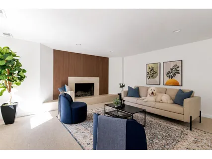 a living room with furniture a potted plant and a fireplace