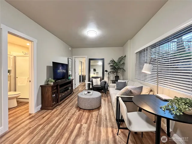 a living room with furniture a flat screen tv and wooden floor