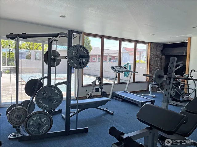 a living room with furniture gym equipment and a large window